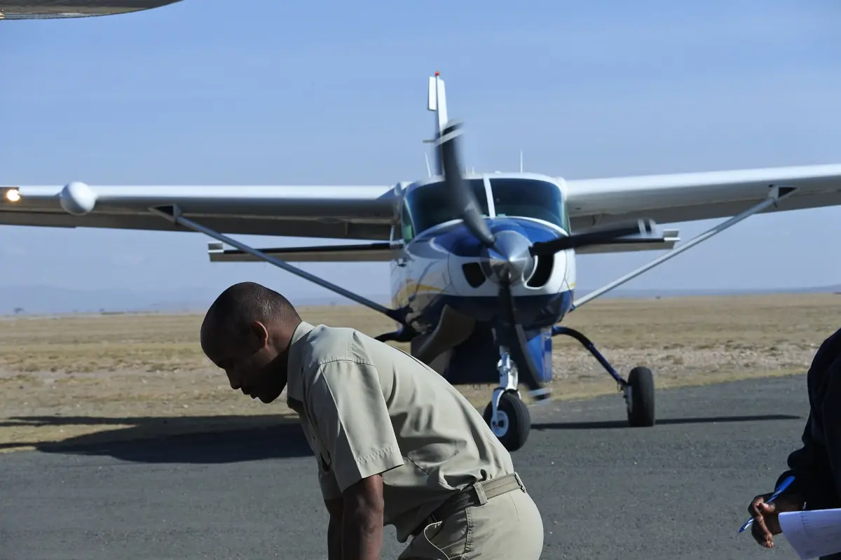 Small Cessna Caravan parked on the Amboseli airstrip with ground crew